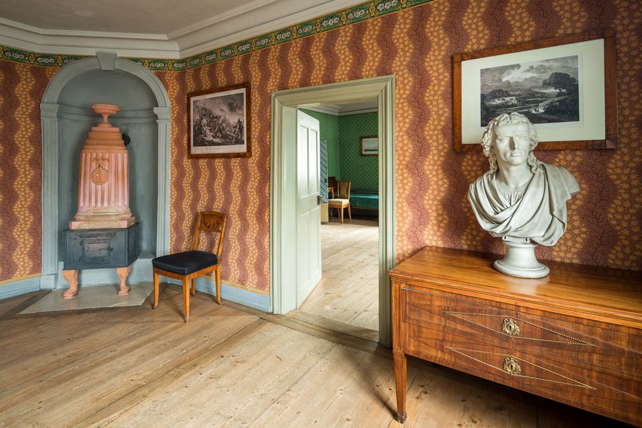 Foto von Zimmer mit buntgemusterten Tapeten und einer Büste von Friedrich Schiller