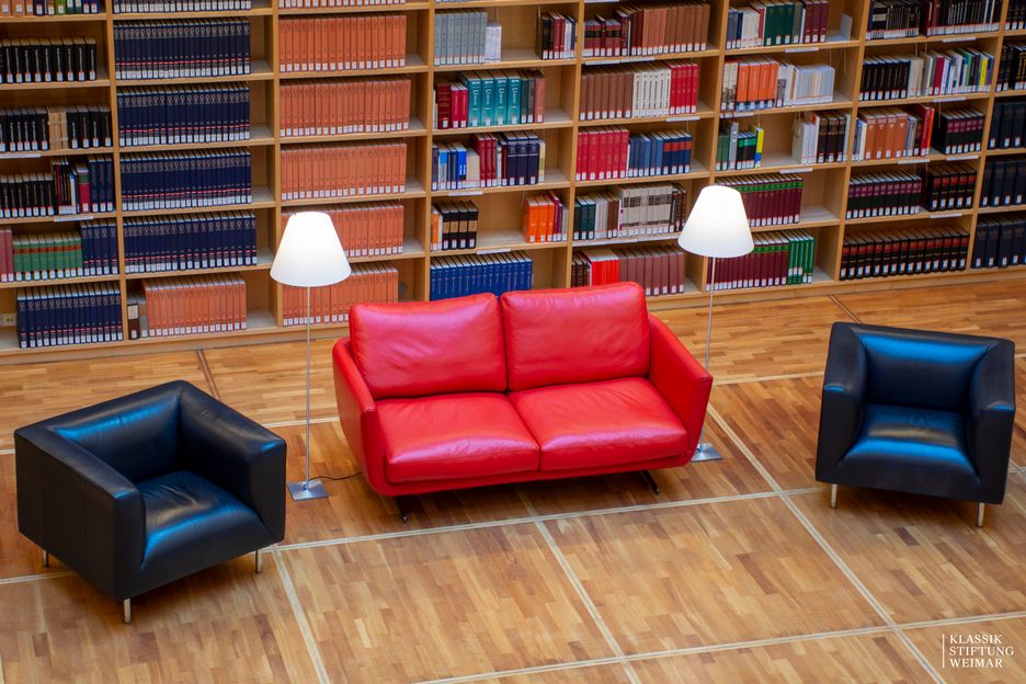 Blick in den Bücherkubus mit rotem Schreiber-Sofa