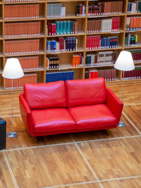 Blick in den Bücherkubus mit rotem Schreiber-Sofa