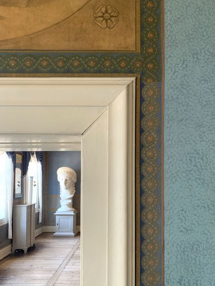 Detail einer Blütenbordüre und Wandfassung im Urbinozimmer