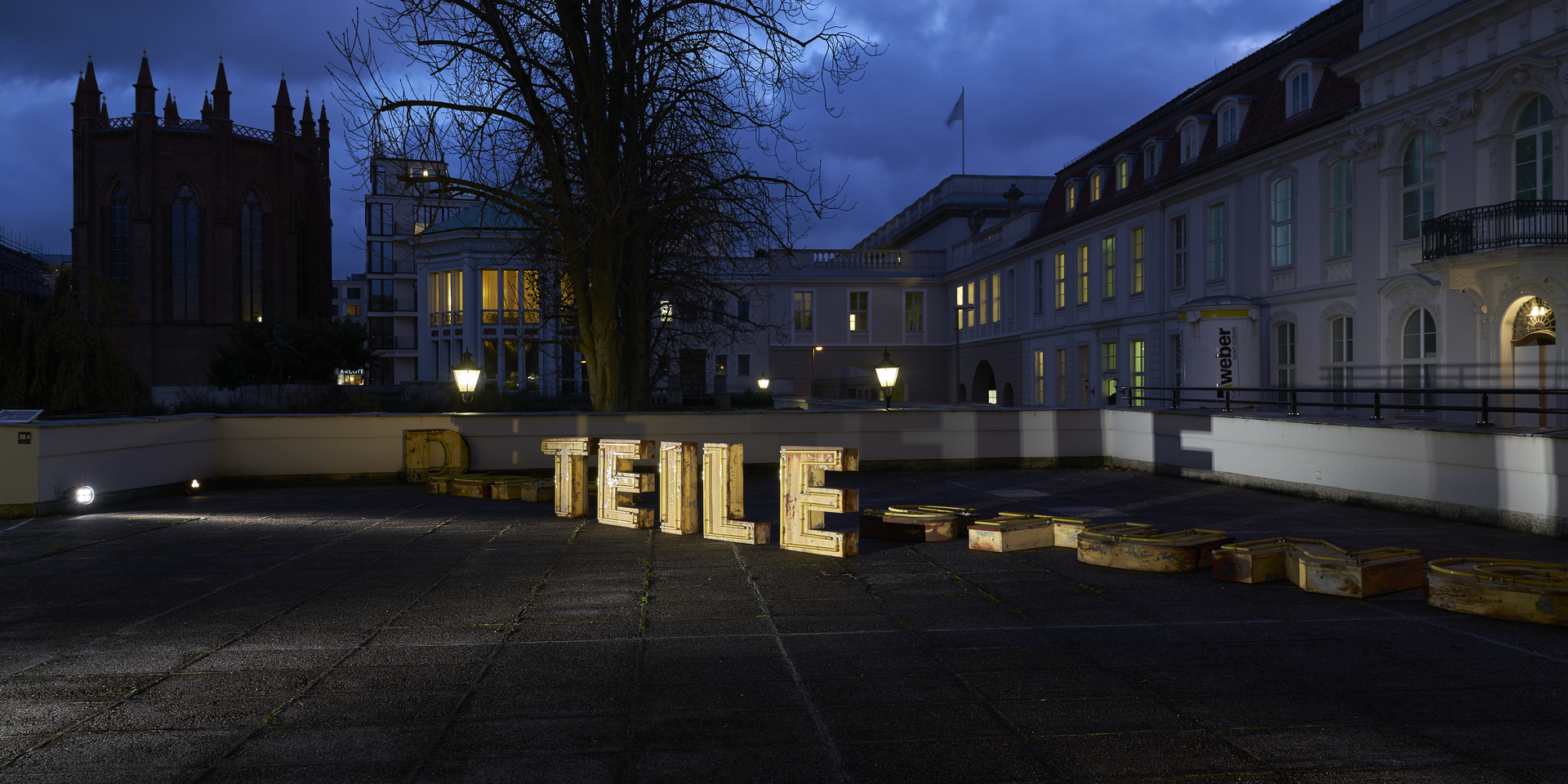 Illuminated installation consisting of letters that make up "parts" is located on a roof terrace