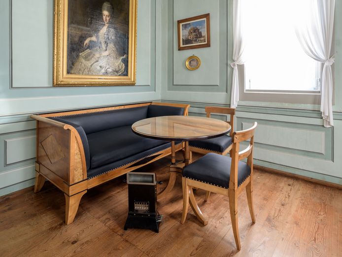 Ein Heizofen vor einem Sofa mit Tisch und Stühlen