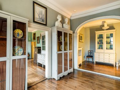 Schränke mit Sammlung flankieren rechts und links den Raum