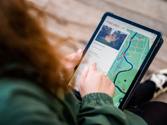 Person bedient ein Tablet, das eine Karte zeigt.