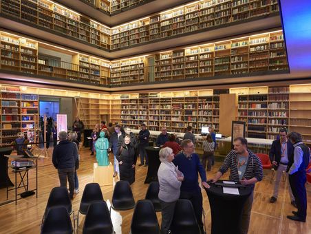 Studienzentrum, Lange Nacht der Wissenschaften 2024 Mehrere Personen flanieren gemütlich durch den Bücherkubus des Studienzentrums und betrachten verschiedene Mitmach-Stationen.