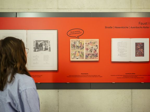 Auf Ausstellungstafeln werden illustrierte Szenen aus dem Faust gezeigt.