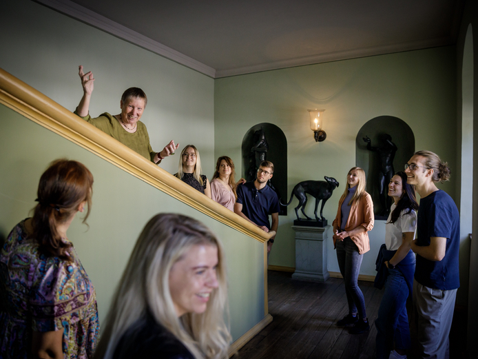 Eine Gruppe mit Guide macht einen Stopp auf einer Treppe, um Skulpturen und Gemälde zu betrachten