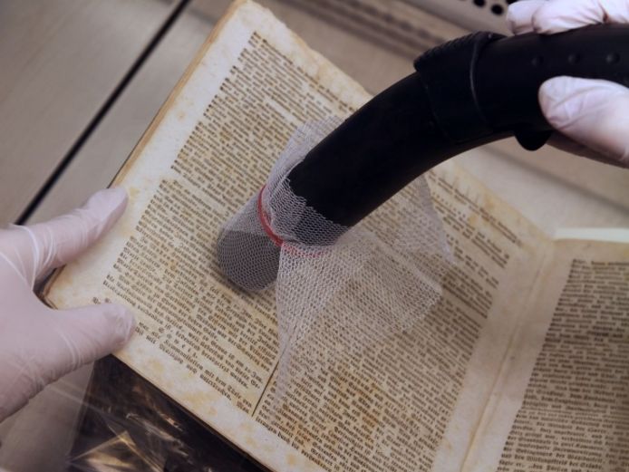 Dry-cleaning a book from Goethe’s private library using a variable-powered vacuum (dust class H).