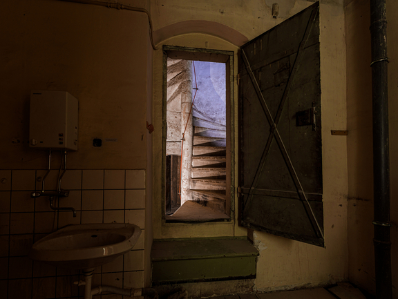 An open room door overlooking a spiral staircase