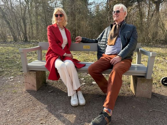 Deux personnes sont assises sur un banc.