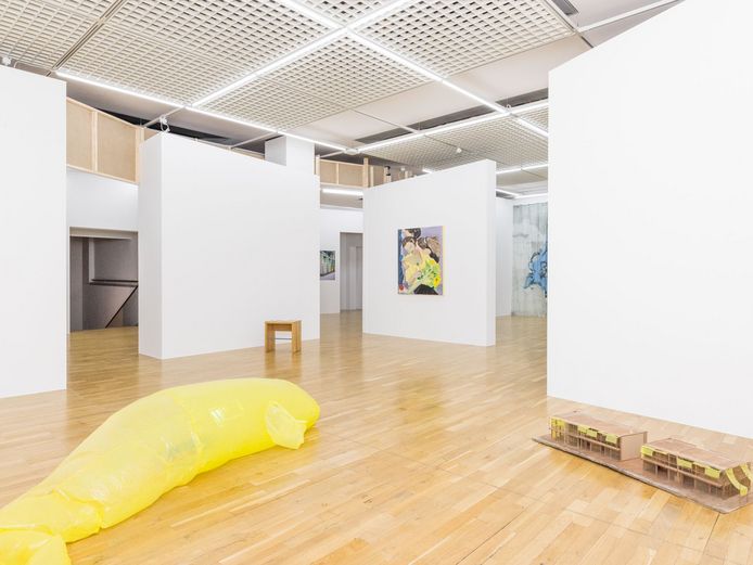 Art installations made of yellow, pillow-like tubes and paintings on the walls