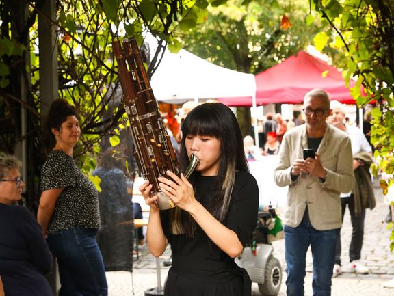 Eine Frau spielt die chinesische Mundorgel Sheng.