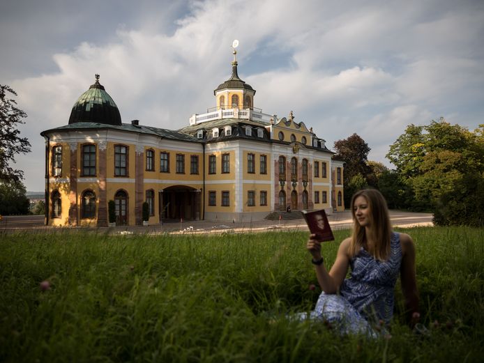 lesende Frau im Gras vor dem Schloss Belvedere