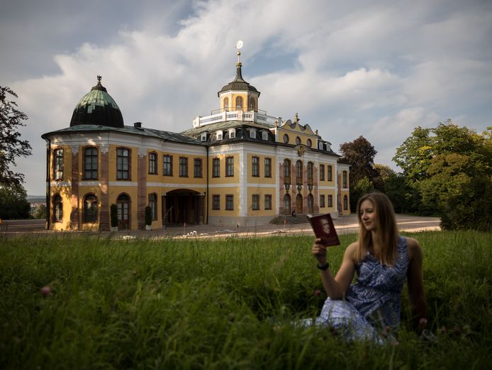 lesende Frau im Gras vor dem Schloss Belvedere
