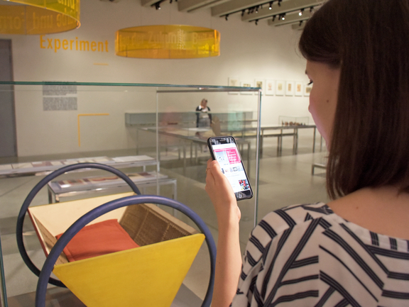 Frau nutzt die App auf ihrem Smartphone im Bauhaus-Museum Weimar
