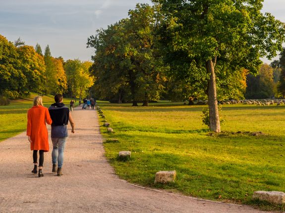Ein junges Paar schlendert durch den Park an der Ilm.