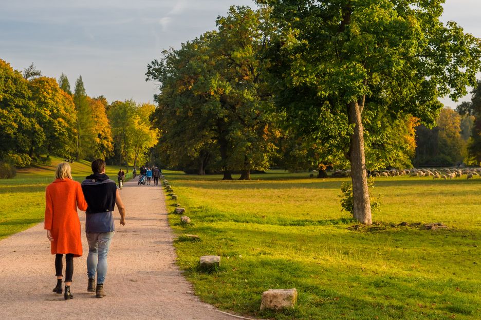 Ein junges Paar schlendert durch den Park an der Ilm.