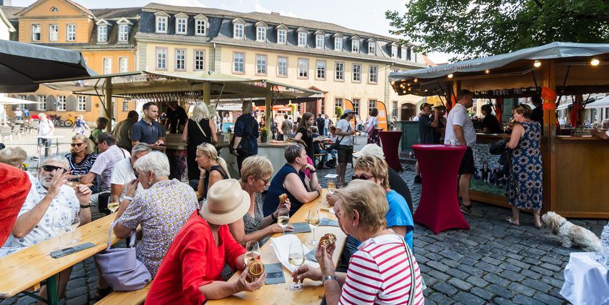 Besucher*innen des Goethe-Geburtstags am Frauenplan sitzen an gut gefüllten Tischen.