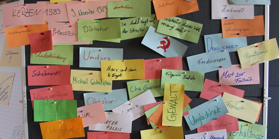 schwarze Pinnwand mit bunten beschriebenen Zetteln