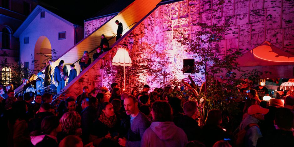 Menschen stehen im Bild verteilt und unterhalten sich.