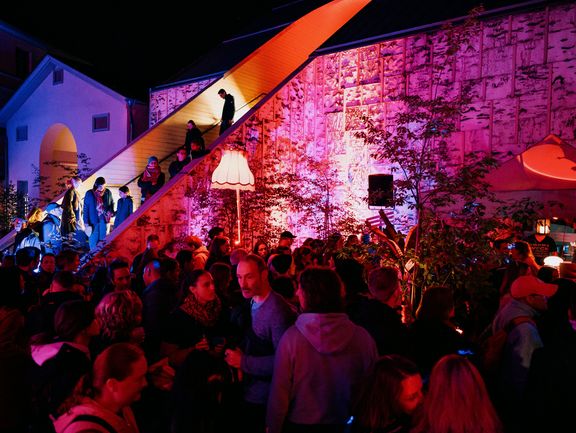 Menschen stehen im Bild verteilt und unterhalten sich.