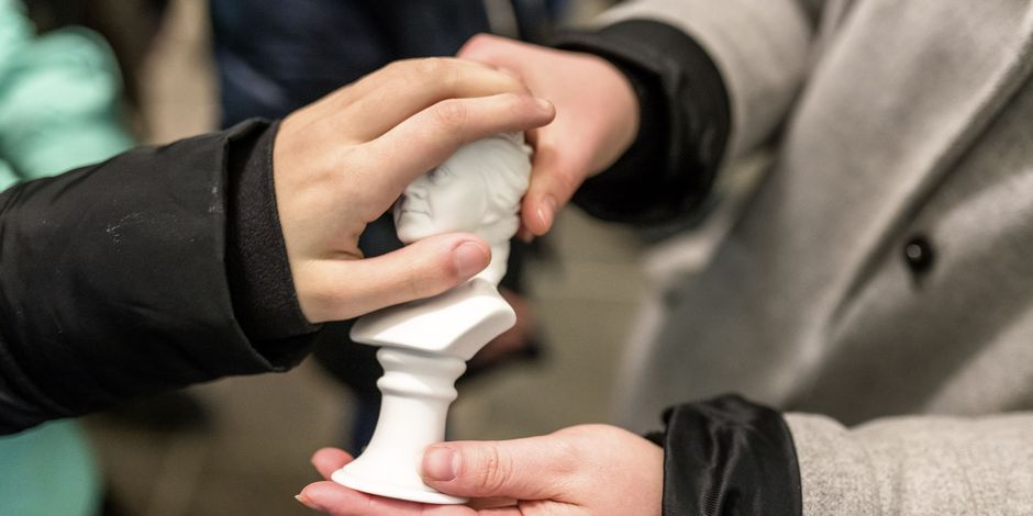 Une main palpe un buste de minature d'une duchesse