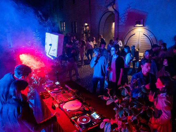 Dj legt auf, um ihn herum tanzen Menschen