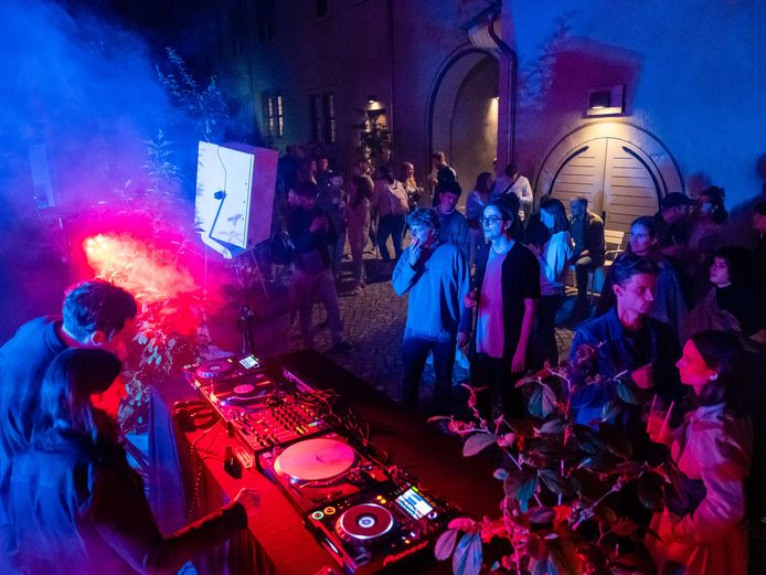 Dj legt auf, um ihn herum tanzen Menschen