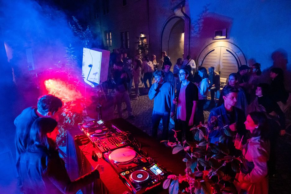 Dj legt auf, um ihn herum tanzen Menschen