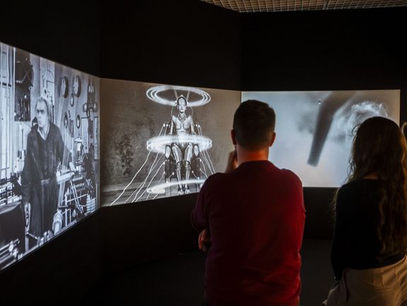 Menschen vor einer Videoleinwand