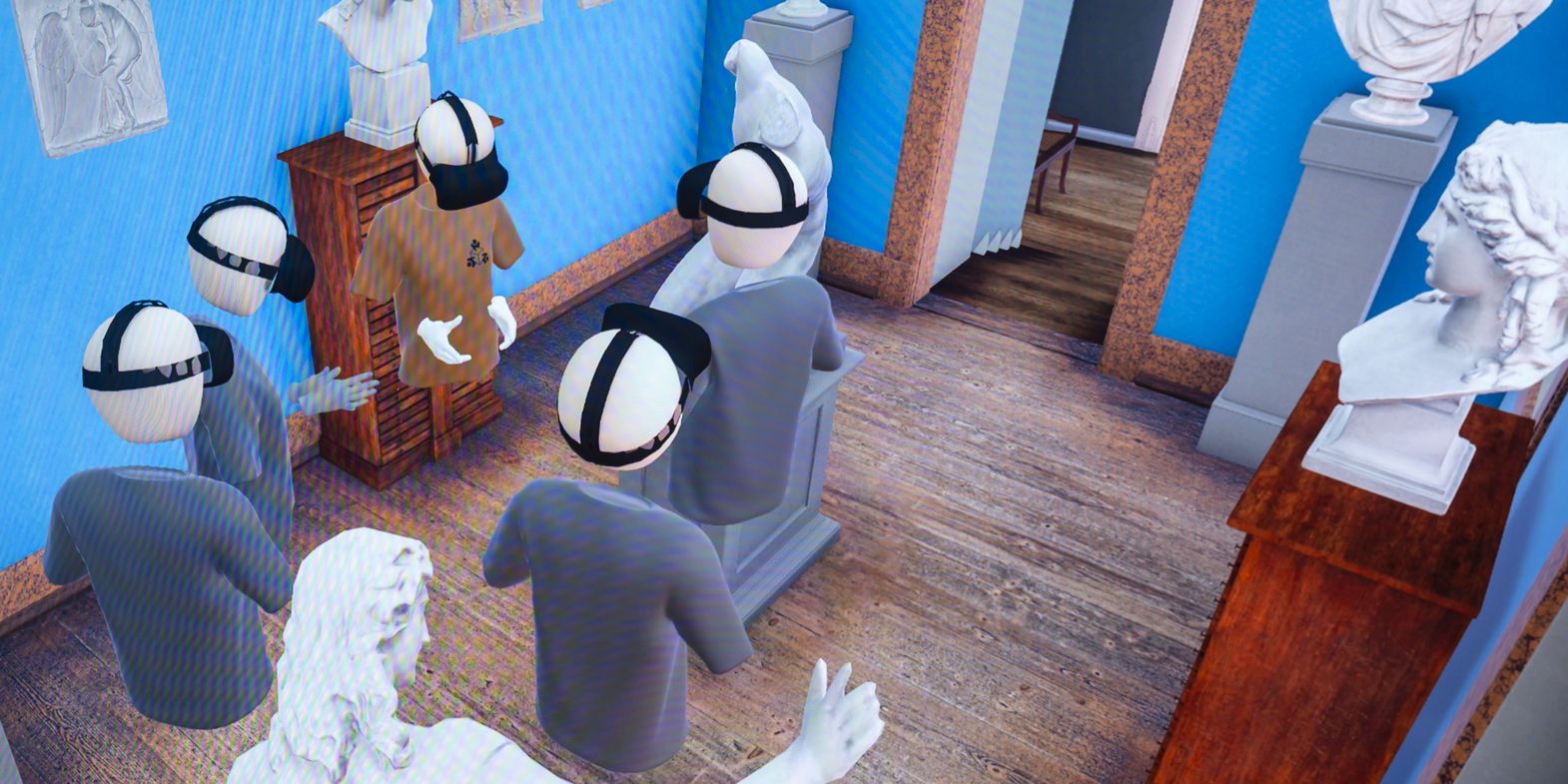 Goethe-Live-3D Das Bild zeigt eine virtuelle Szene in einem Raum mit blauen Wänden und einem Holzboden. Mehrere Avatare, die VR-Headsets tragen, stehen in der Mitte des Raumes. Um sie herum befinden sich verschiedene Statuen und Büsten auf Sockeln. An den Wänden hängen gerahmte Bilder und Skizzen. Im Hintergrund ist eine Treppe zu sehen, die nach oben führt, sowie eine offene Tür, die in einen anderen Raum führt. Die Szene wirkt wie eine virtuelle Kunstgalerie oder ein Museum.