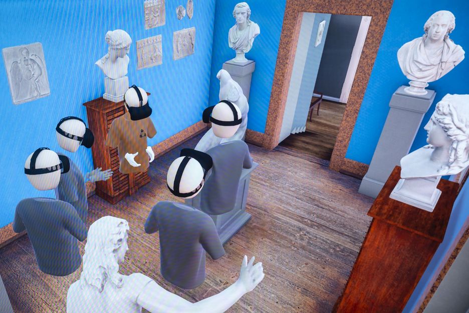Das Bild zeigt eine virtuelle Szene in einem Raum mit blauen Wänden und einem Holzboden. Mehrere Avatare, die VR-Headsets tragen, stehen in der Mitte des Raumes. Um sie herum befinden sich verschiedene Statuen und Büsten auf Sockeln. An den Wänden hängen gerahmte Bilder und Skizzen. Im Hintergrund ist eine Treppe zu sehen, die nach oben führt, sowie eine offene Tür, die in einen anderen Raum führt. Die Szene wirkt wie eine virtuelle Kunstgalerie oder ein Museum.