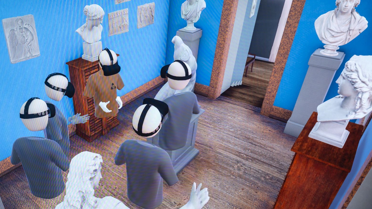 Goethe-Live-3D Das Bild zeigt eine virtuelle Szene in einem Raum mit blauen Wänden und einem Holzboden. Mehrere Avatare, die VR-Headsets tragen, stehen in der Mitte des Raumes. Um sie herum befinden sich verschiedene Statuen und Büsten auf Sockeln. An den Wänden hängen gerahmte Bilder und Skizzen. Im Hintergrund ist eine Treppe zu sehen, die nach oben führt, sowie eine offene Tür, die in einen anderen Raum führt. Die Szene wirkt wie eine virtuelle Kunstgalerie oder ein Museum.