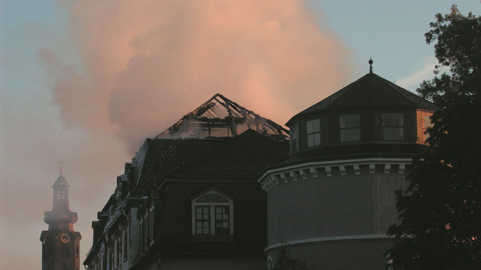 Der verbrannte Dachstuhl der Bibliothek im Morgenlicht, im Hintergrund der Schlossturm
