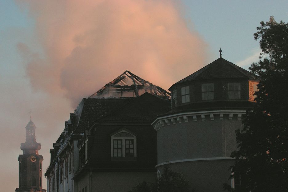 Der verbrannte Dachstuhl der Bibliothek im Morgenlicht, im Hintergrund der Schlossturm