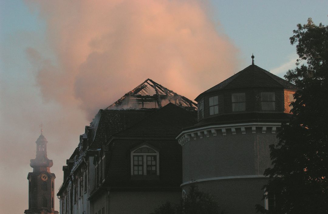 Der verbrannte Dachstuhl der Bibliothek im Morgenlicht, im Hintergrund der Schlossturm