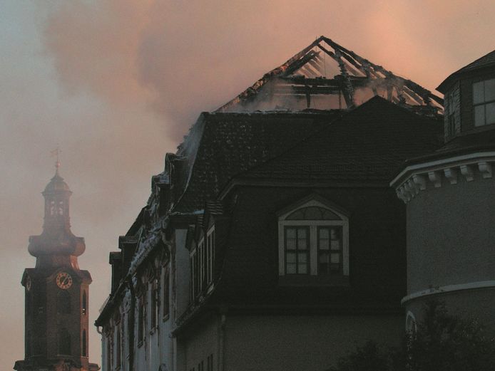 Der verbrannte Dachstuhl der Bibliothek im Morgenlicht, im Hintergrund der Schlossturm