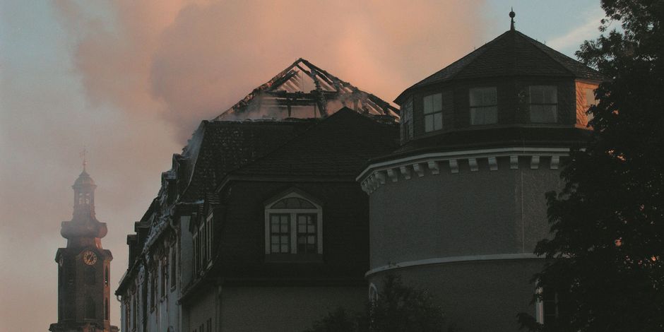 Der verbrannte Dachstuhl der Bibliothek im Morgenlicht, im Hintergrund der Schlossturm