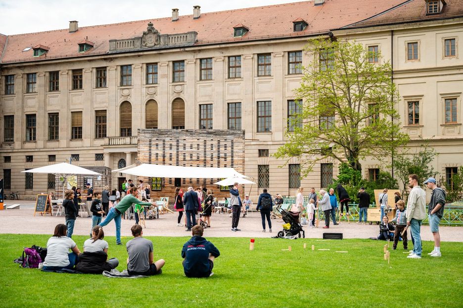 Menschen genießen die Wiese und Aktionen des Co-Labors vor dem Weimarer Schloss.