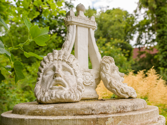 Eine Lyra und Masken schmücken das Mozart-Denkmal.