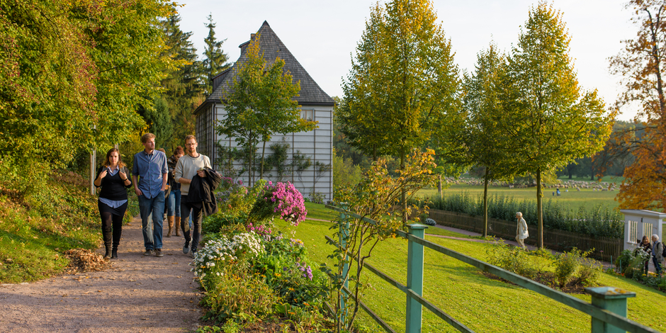 Erwachsenengruppe läuft durch den blühenden Garten am Goethe Gartenhaus