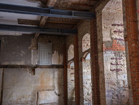 Schloss erzählen Ansicht eines Steingewölbes mit Stahlträgern und einer kleinen Tür