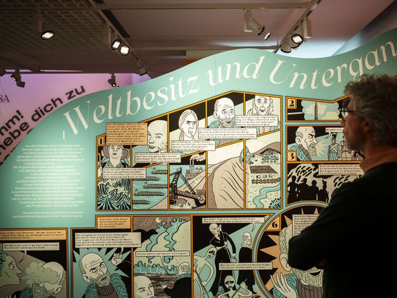 Ein Mann steht vor einer großen Comic-Wand