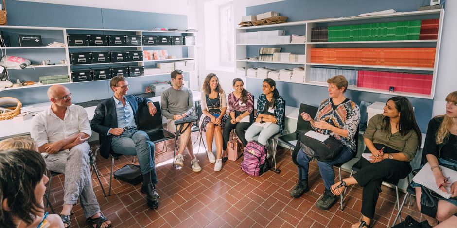 Personen verschiedener Altergruppen unterhalten sich angeregt in einem Stuhlkreis 